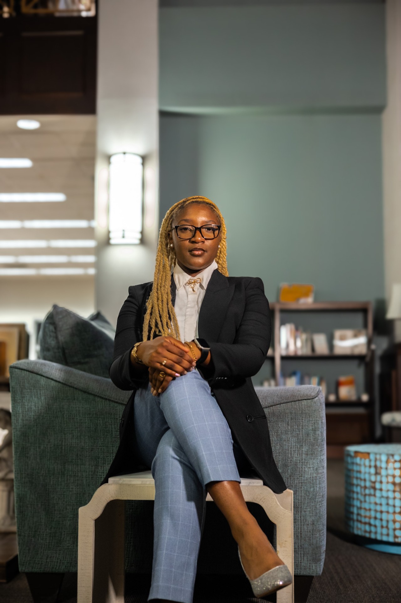 Nzinga Collins seated in a blazer, looking confidently at the camera
